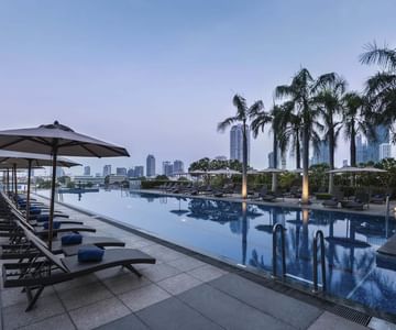 Pool area with pool chairs at Chatrium Hotels & Residences  