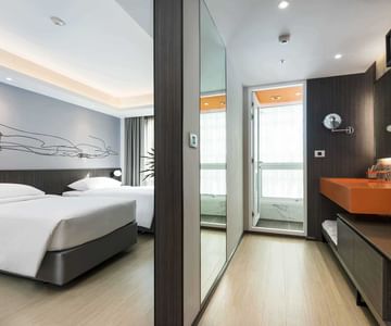 A room with two beds at Maitria Hotels & Residences